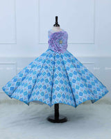 Lavender and Sky Blue Sleeveless Top With A Flower Accent, Paired With Flared Blue Printed Panel Skirt For A Stylish Party Look