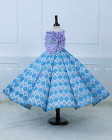 Lavender and Sky Blue Sleeveless Top With A Flower Accent, Paired With Flared Blue Printed Panel Skirt For A Stylish Party Look