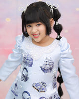 Light Blue A-Line Top With Printed Blue Motifs, Pearl Accents, And An Embroidered Neck.