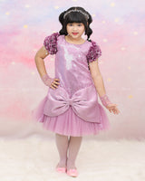 Shimmery Pink Dress With Satin Flower Sleeves Adorned With Pearl Tassels And A Large Bow Accent.