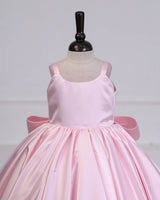 Princess-style pink gown with a flowing trail and large back bow.