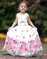 White Crop Top Paired With A Flared Skirt Featuring Vibrant Pink Floral Embroidery Along The Hem