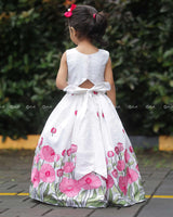 White Crop Top Paired With A Flared Skirt Featuring Vibrant Pink Floral Embroidery Along The Hem