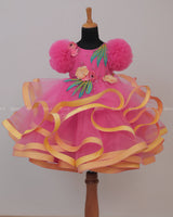 Flamingo Pink Twirled Gown Embellished with Artificial Flowers and Greenish Blue Petals