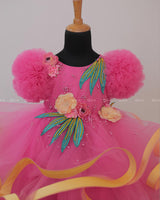 Flamingo Pink Twirled Gown Embellished with Artificial Flowers and Greenish Blue Petals