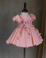 Butterfly and Floral Theme Peach Frock with Attached Bows in waistline and Applique Works.