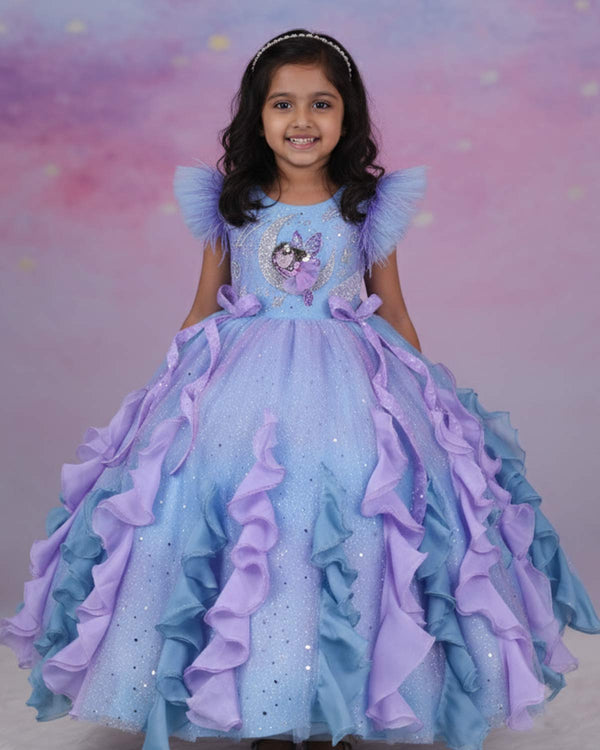 A dreamy lilac-blue fairy gown with butterfly details, side bows, and sparkling ruffles.