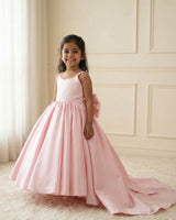 Princess-style pink gown with a flowing trail and large back bow.