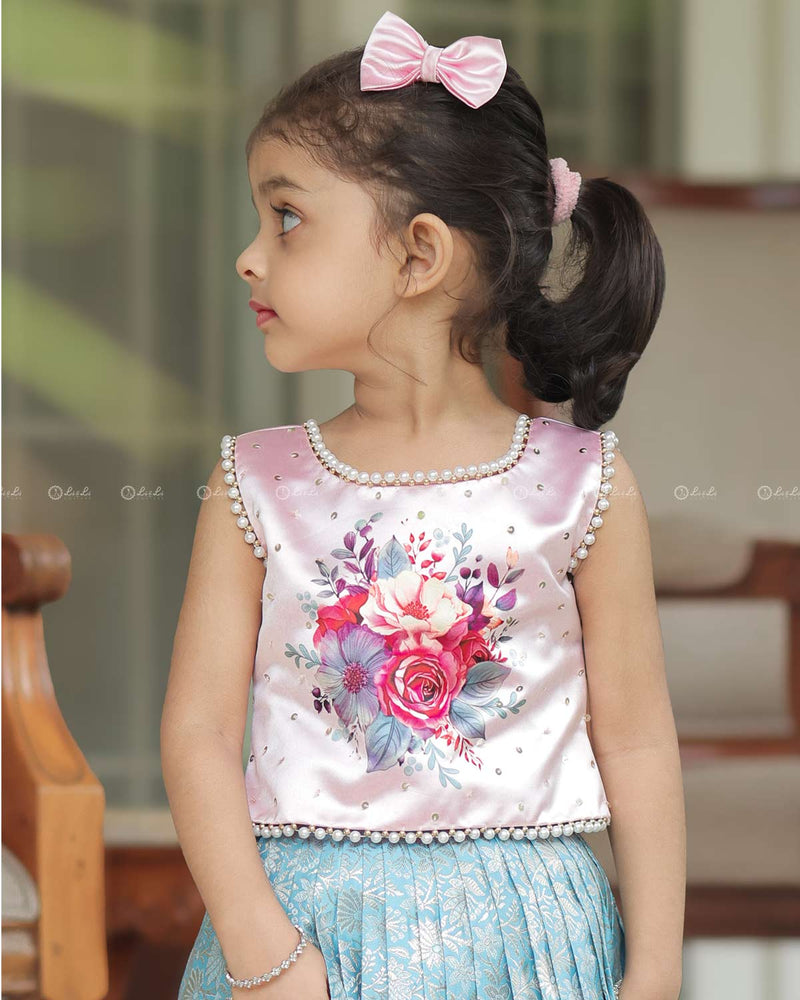 Sleeveless Pink Top With Floral Print And Pearls, Paired With Pleated Blue Brocade Skirt And Golden Lace Hem