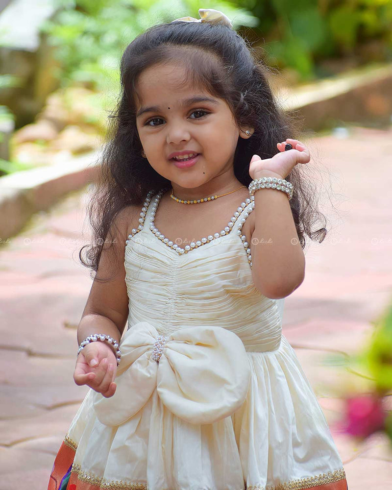 Ivory Frock With Pearl Neckline, Ruched Yoke, Waist Bow And Floral Woven Border