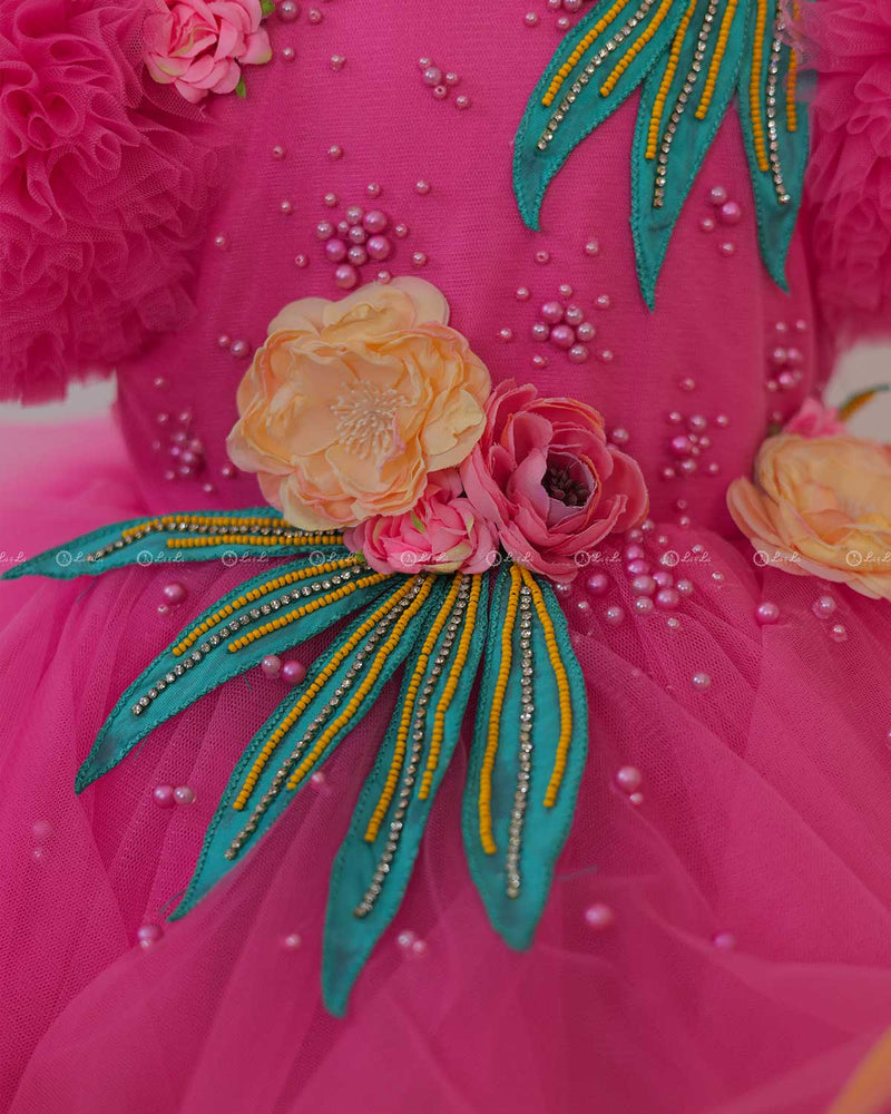 Flamingo Pink Twirled Gown Embellished with Artificial Flowers  and Greenish Blue Petals