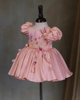 Butterfly and Floral Theme Peach Frock with Attached Bows in waistline and Applique Works.