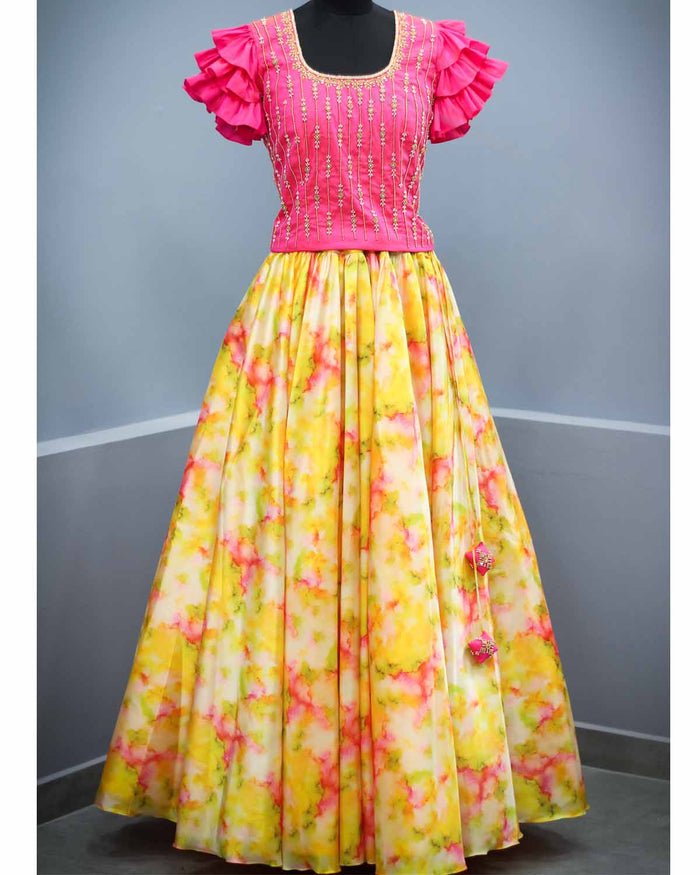 Woman in fuchsia hand worked top with frill sleeves and shibori print skirt